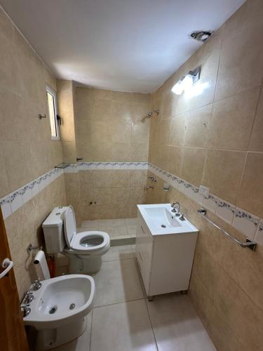 a bathroom with a toilet and a sink at Hostal Del Sol Temporario in Rosario