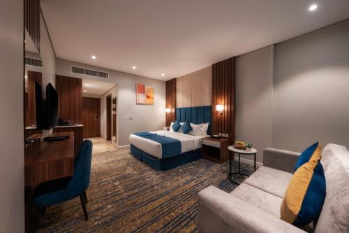 ein Hotelzimmer mit einem Bett und einem Sofa in der Unterkunft القصر الكورنيش in Dschāzān