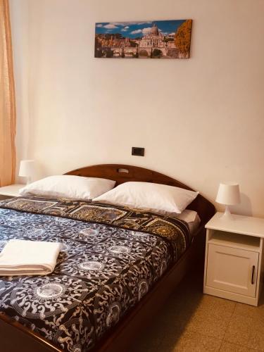1 cama en un dormitorio con una foto en la pared en San Giovanni Apartment, en Roma