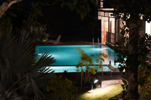 a swimming pool at night with a lightedledgedledgedledgedledgedledgedledgedledged at Blanket Days Resort and Spa in Thekkady