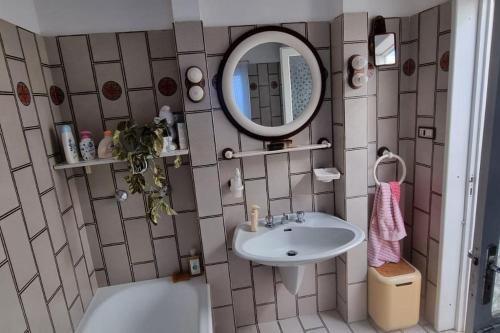 y baño con lavabo, espejo y bañera. en La casa di nonna Ivola, en Tocco da Casauria
