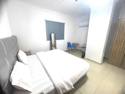 a white bedroom with a bed and a chalkboard at القبة الذهبية للشقق المخدومة in Riyadh