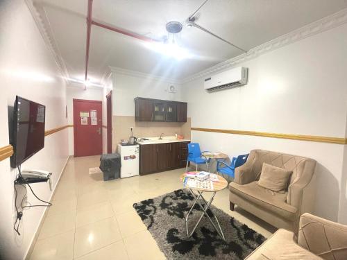 a living room with a couch and a kitchen at القبة الذهبية للشقق المخدومة in Riyadh