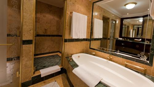 baño con bañera y espejo grande en Walmont at Graceland, en Secunda