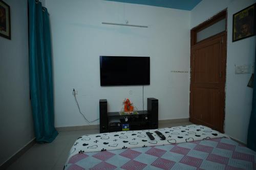 a bedroom with a bed and a flat screen tv at Hill crest Kb Restaurant banquet in Kota Bāgh
