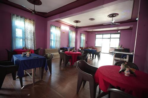 ein Esszimmer mit Tischen, Stühlen und lila Wänden in der Unterkunft Hill crest Kb Restaurant banquet in Kota Bāgh