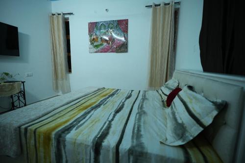 Schlafzimmer mit einem Bett mit Wandgemälde in der Unterkunft Hill crest Kb Restaurant banquet in Kota Bāgh