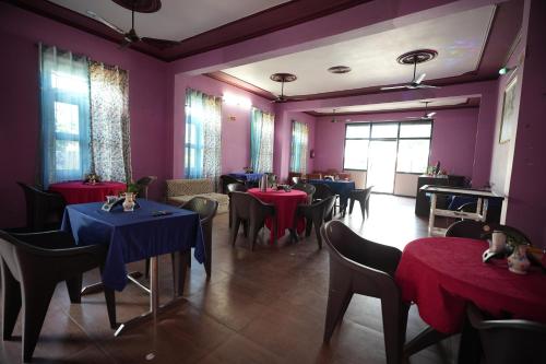 Kota Bāgh的住宿－Hill crest Kb Restaurant banquet，一间设有桌椅和紫色墙壁的用餐室