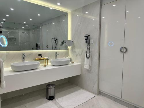 a bathroom with two sinks and a shower at Pearl Continental Hotel, Bhurban in Bhurban