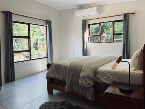 Un dormitorio con una cama y dos ventanas. en Witrivier Farmstay Self-Catering, en Cambria