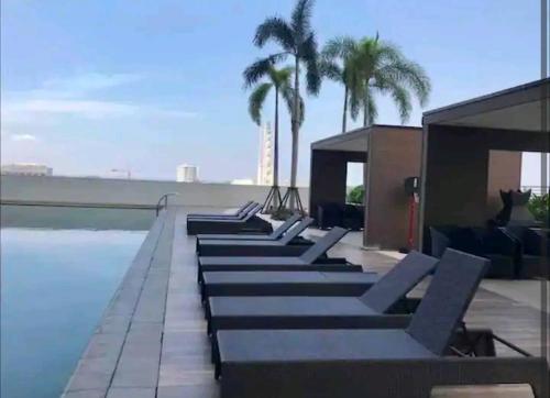 a row of lounge chairs next to a swimming pool at Smdc Breeze Residence in Manila
