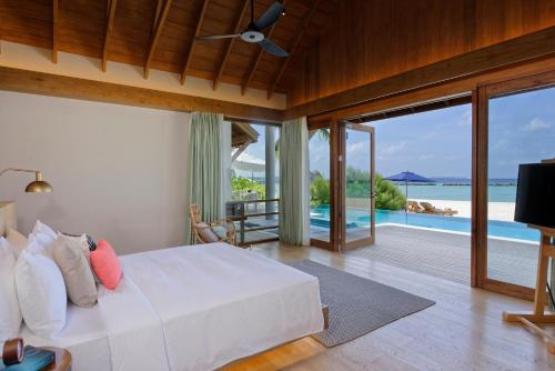 a bedroom with a bed and a view of the ocean at Emerald Faarufushi Resort & Spa - Deluxe All Inclusive in Raa Atoll