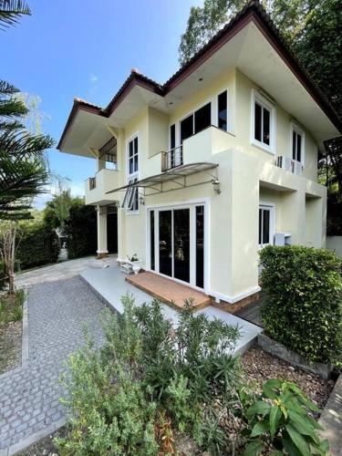 a large white house with a courtyard at Private Pool Villa , 4BR, Fast WiFi, BBQ Garden in Ban Dan Mai