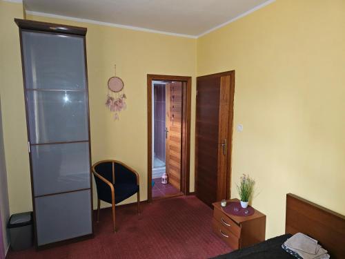 a room with a bed and a chair and a door at Ubytovani Stodolni in Moravská Ostrava