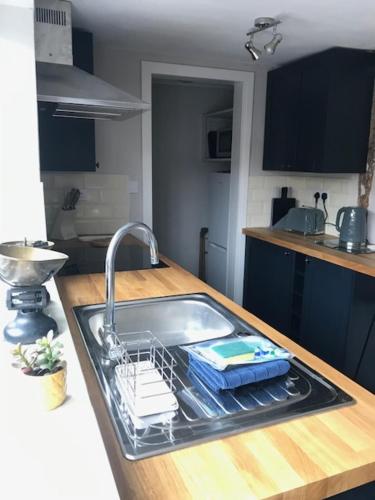 a kitchen sink with a dish drying rack on it at Almond Cottage Clare - 2 bedroom English Cottage in Clare
