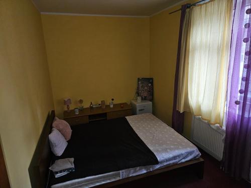 a small bedroom with a bed and a window at Ubytovani Stodolni in Moravská Ostrava