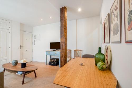 ein Wohnzimmer mit einem Holztisch und einem Schreibtisch in der Unterkunft 1 bedroom 1 bathroom furnished - Malasaña - Modern in downtown area - MintyStay in Madrid