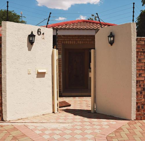 a small white building with a brown door at Renosterberg by KLG in Kimberley