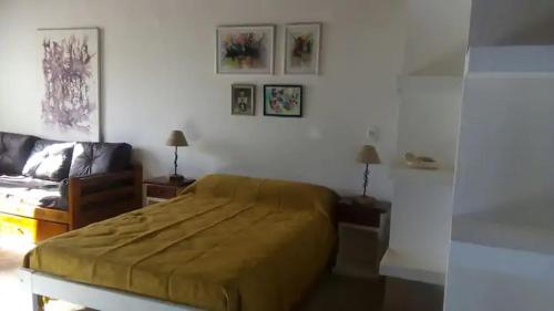 - une chambre avec un lit et un canapé dans l'établissement Monoambiente Luminoso (permitido mascotas), à Camet Norte