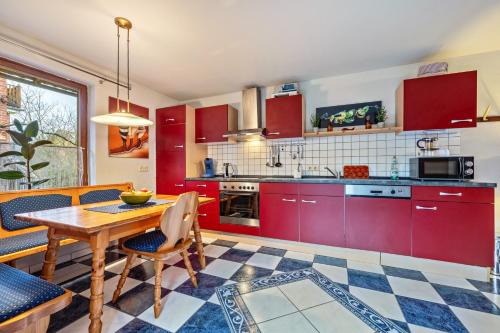 a kitchen with red cabinets and a table and chairs at Einzimmer Appartment in Heckenbeck in Bad Gandersheim