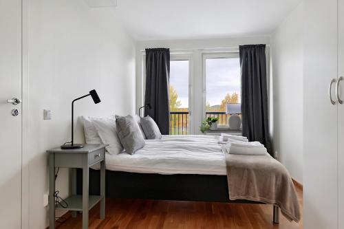 a white bedroom with a bed and a window at Guestly Homes - 1BR Corporate Comfort in Boden