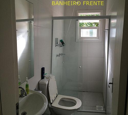 W łazience znajduje się toaleta, umywalka i prysznic. w obiekcie Casa em Capao w mieście Capão da Canoa