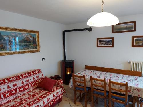sala de estar con mesa y sofá en Trilocale BELVEDERE Alloggio ad uso turistico - VDA - LA THUILE - CIR 0068, en La Thuile