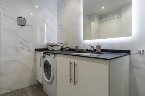 a white bathroom with a sink and a washing machine at Brigth- Pool Parking-1Bd 1Bth-Prado in Madrid