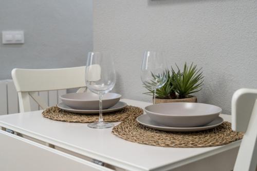 a table with two wine glasses and plates on it at Wide & modern- 3Bd 1Bth- Delicias in Madrid