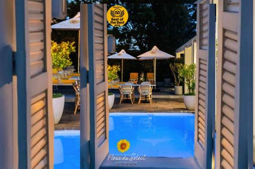 a view of a pool with tables and umbrellas at Fleur du Soleil Luxury Guesthouse in Franschhoek
