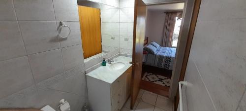 ein Bad mit einem Waschbecken und einem Spiegel in der Unterkunft Cabaña a pasos costanera in Puerto Varas