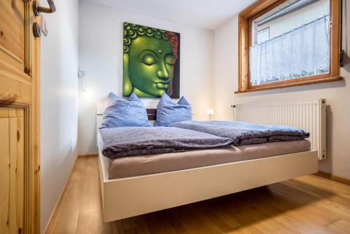 1 dormitorio con 1 cama con una cara verde en la pared en Fewo mit Behelfsküche in Heckenbeck, en Bad Gandersheim