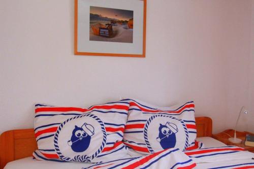 a bed with red white and blue pillows on it at Bungalow Nixe in Tarnewitz