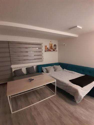 ein Schlafzimmer mit einem Bett und einem Couchtisch in der Unterkunft Inalux Apartmani Pale in Gornje Pale