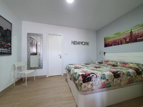 ein Schlafzimmer mit einem Bett und einem Schild an der Wand in der Unterkunft NEW YORK - LA COLINA in San Miguel de Meruelo