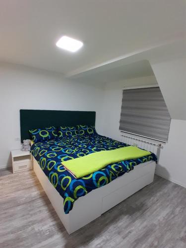 ein Schlafzimmer mit einem Bett mit einer bunten Decke darauf in der Unterkunft Inalux Apartmani Pale in Gornje Pale