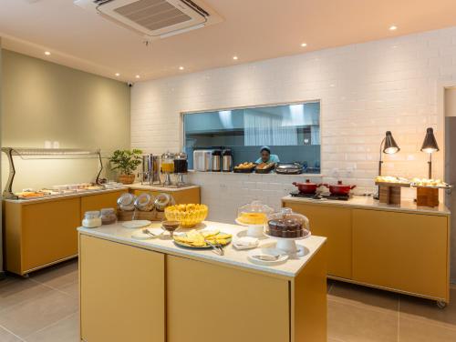 a kitchen with a buffet of food on a table at B&B HOTEL Santos Dumont in Rio de Janeiro