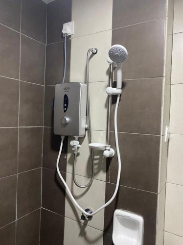 a shower in a bathroom with a toilet at Omak Kito Homestay Melaka in Kampong Alor Gajah