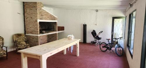 Habitación con mesa de madera y chimenea de ladrillo. en El buen verano, en Ciudad de la Costa