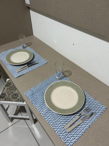 uma mesa com dois pratos e utensílios em Res. Hostel em Santa Cruz do Sul