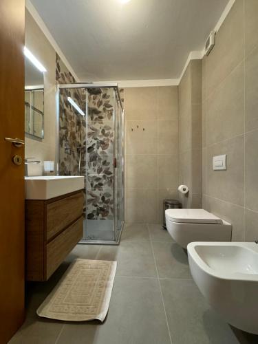 a bathroom with two sinks a toilet and a shower at Residence Betulla Molveno in Molveno