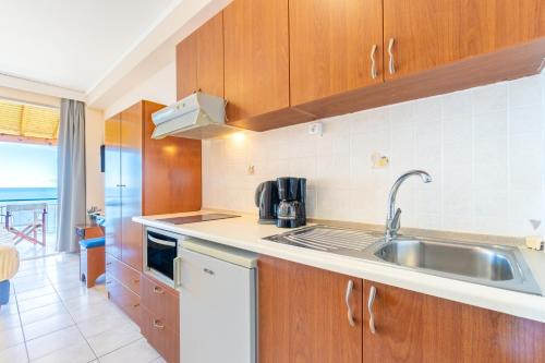 a kitchen with a sink and a counter top at Lido Sofia Apartments in Agios Gordios