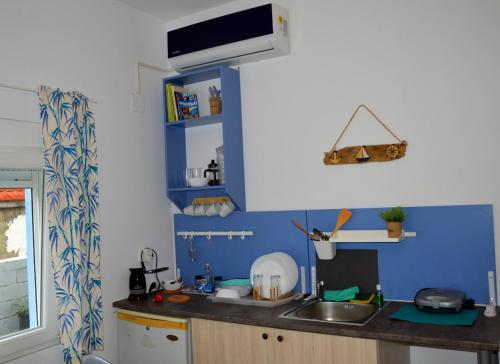 a kitchen with a sink and a blue wall at Gabari Studio in Boúkka