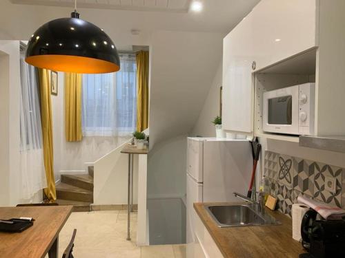 a small kitchen with a sink and a refrigerator at 80 - Paris Cinema Sebastopol in Paris