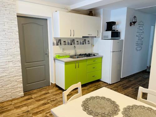 een keuken met een groen eiland en een witte koelkast bij Casa Ceteras in Cavnic