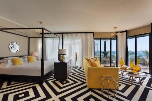 ein Schlafzimmer mit einem Bett, einem Sofa und einem Tisch in der Unterkunft Brown Beach House Tel-Aviv, a member of Brown Hotels in Tel Aviv