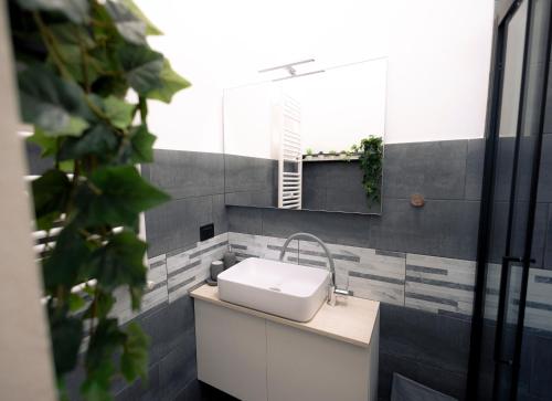 y baño con lavabo blanco y espejo. en tHE Keith Haring Home en Milán