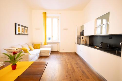 sala de estar con sofá blanco y cocina en tHE Keith Haring Home en Milán