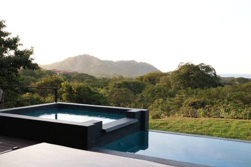 a swimming pool with a view of a mountain at Casa Mon Coeur-Playa Del Coco Ocean View in Coco