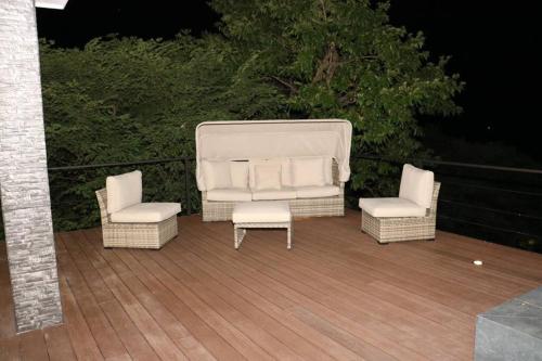 two chairs and a couch and two chairs on a deck at Casa Mon Coeur-Playa Del Coco Ocean View in Coco